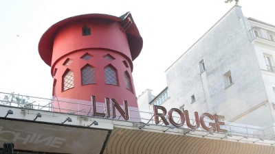 Arbeiter sichern den Bereich vor dem Kabarett, nachdem die Flügel des Windrads des „Moulin Rouge“ in der Nacht abgestürzt sind. (Foto: Geoffroy Van Der Hasselt/AFP/dpa)
