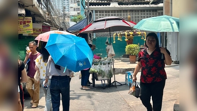Menschen schützen sich in Bangkok mit Schirmen vor der extremen Hitze und vor der Sonne. (Foto: Carola Frentzen/dpa)