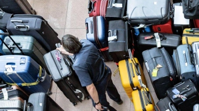 Stau bei der Gepäckabfertigung: Nach dem Ausfall einer Sortieranlage am Hamburger Flughafen, müssen die Koffer und Taschen von Hand zugeordnet und zu den Maschinen gebracht werden. (Foto: Markus Scholz/dpa)