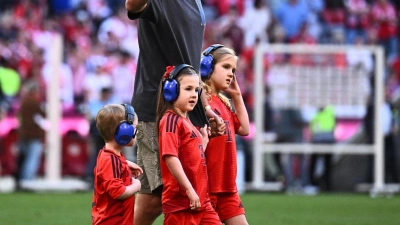 Münchens Harry Kane geht mit Kindern nach dem Spiel auf dem Spielfeld. (Foto: Tom Weller/dpa)