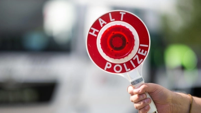 Ein Polizist hält bei einer Verkehrskontrolle eine Polizeikelle in der Hand. (Foto: Jonas Güttler/dpa/Symbolbild)